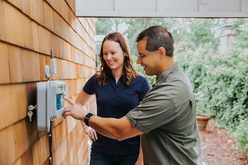 Two People Standing at a Water Meter