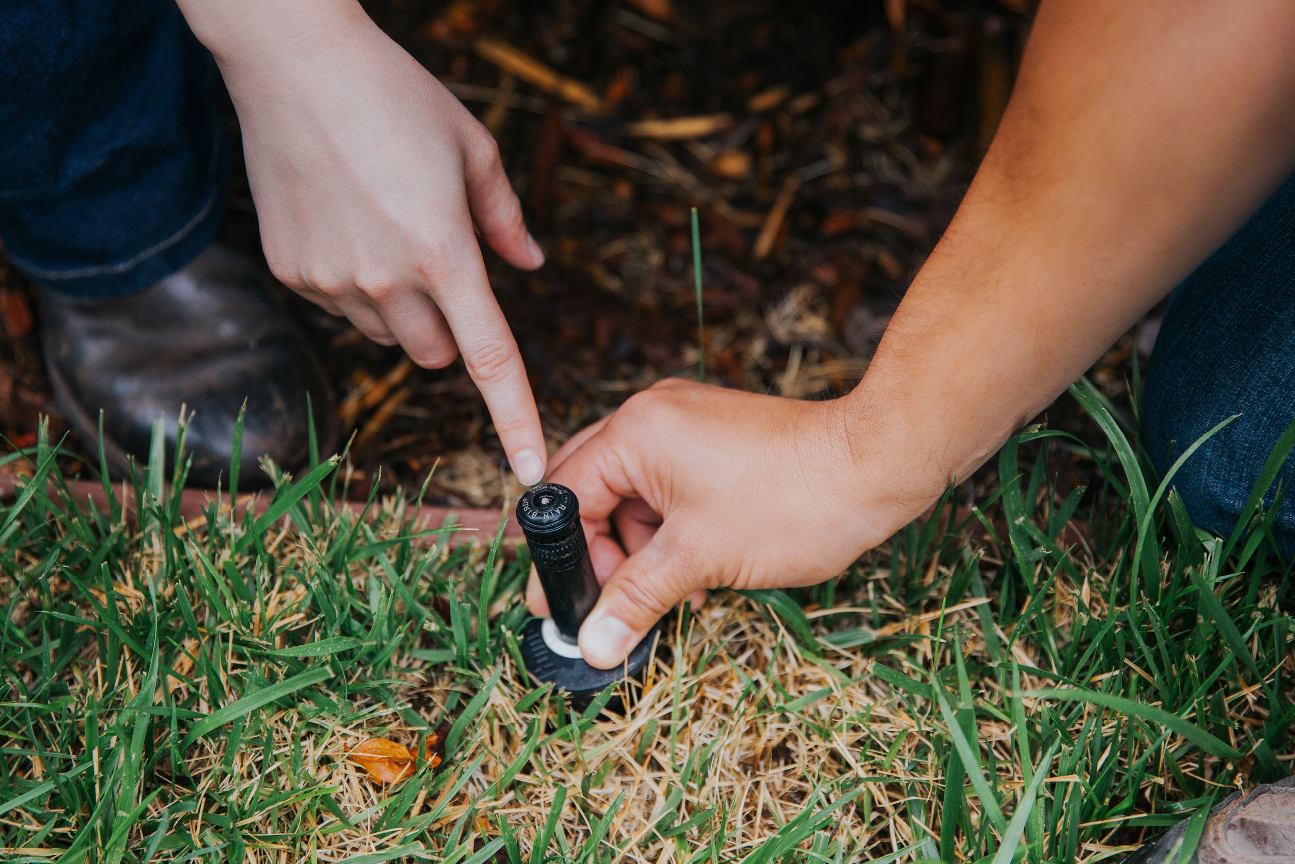 adjusting sprinkler with hands